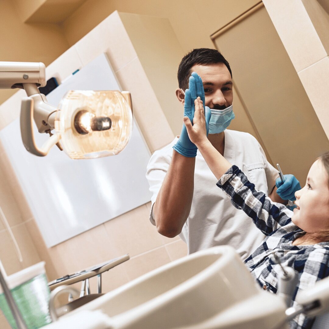 A dentist greeting a young patient to put them at ease before treatment
