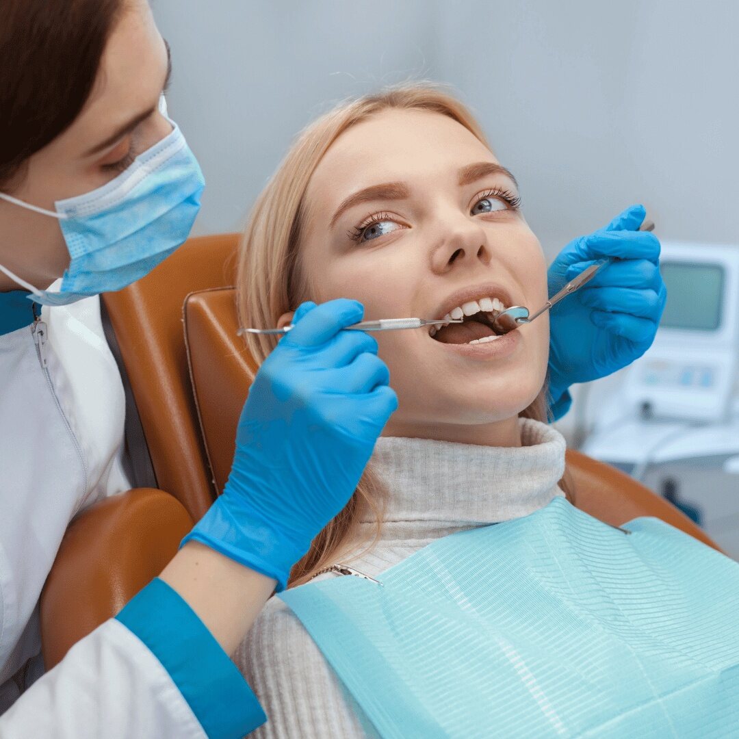 A dentist and assistant treating a patient together at the chairside