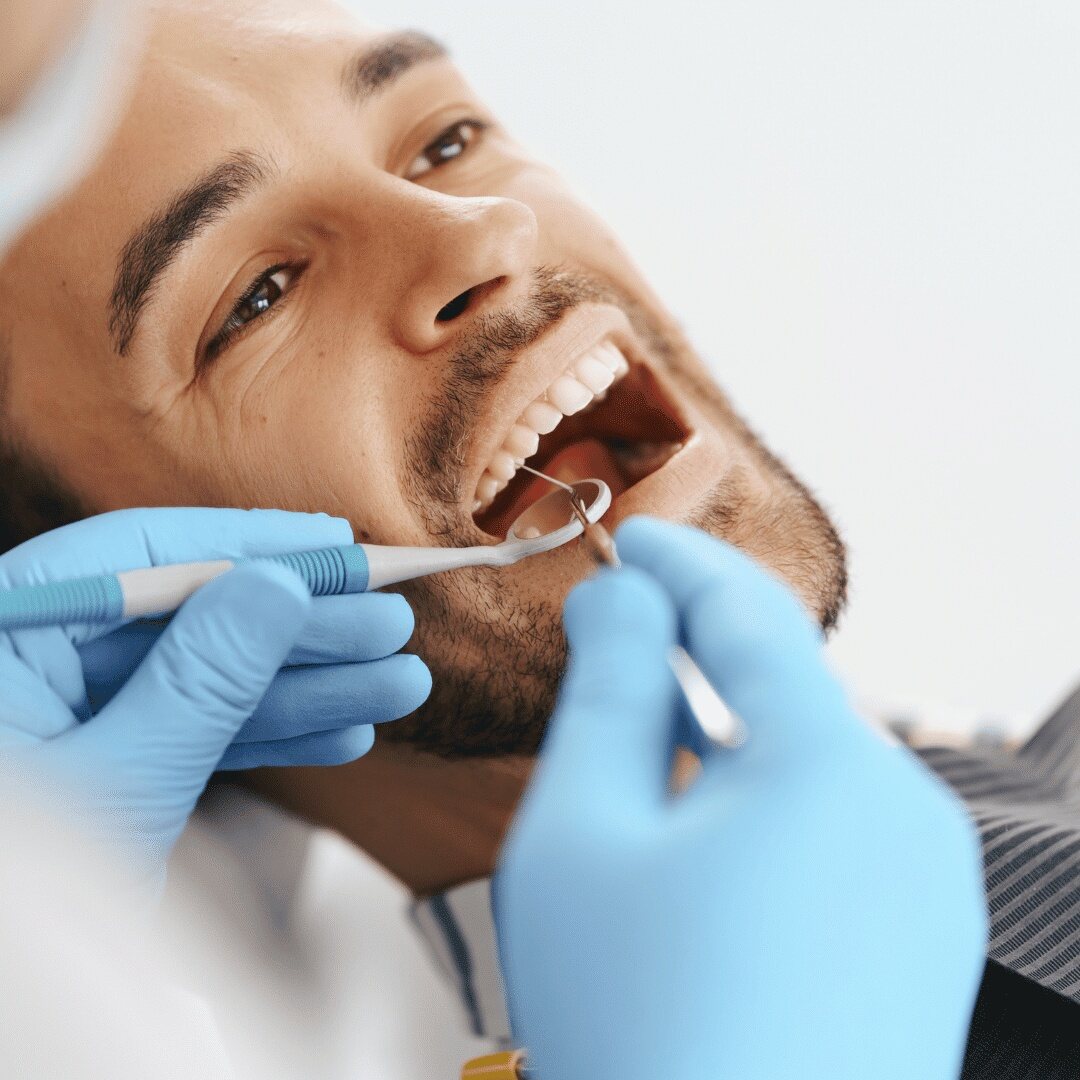 A patient having his teeth examined with a mirror and probe