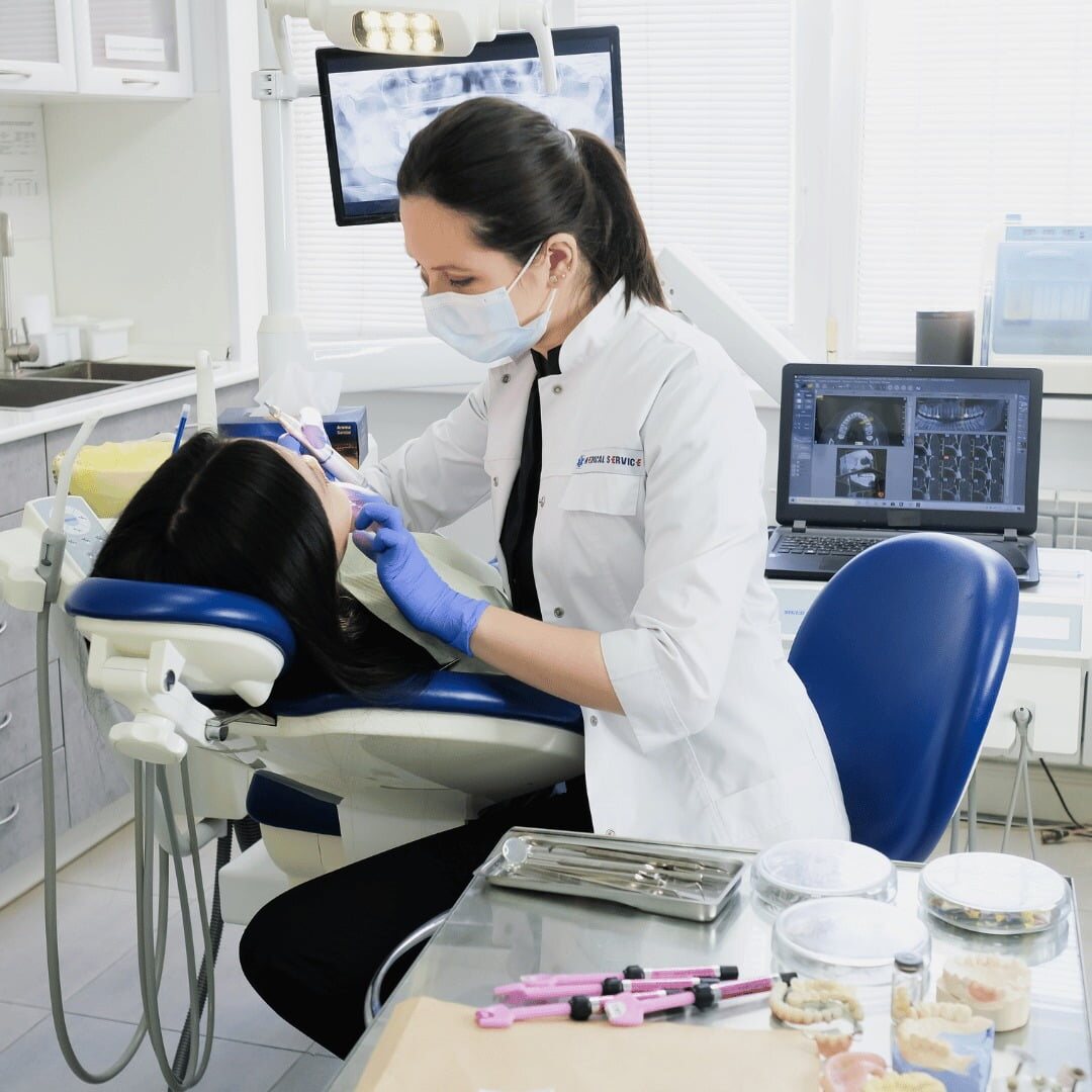 A dentist treating a patient with digital X-rays displayed on the chairside monitor