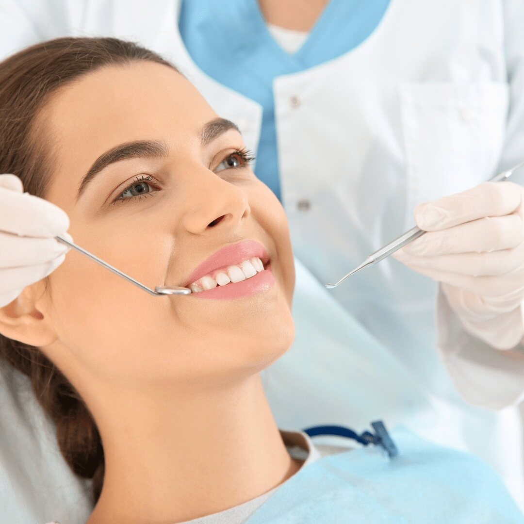 A patient smiling as the dentist reviews her teeth after treatment