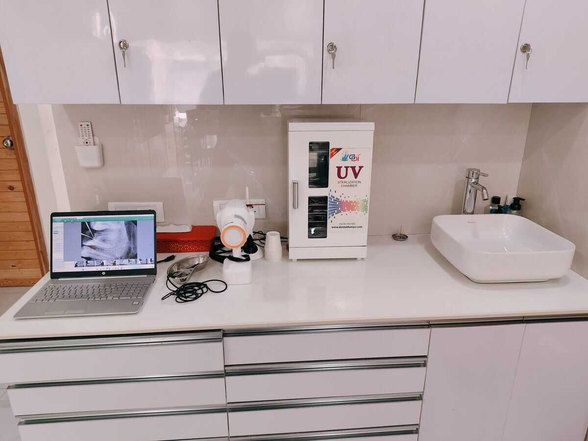 The sterilization station at Mahavirai Dental, with a UV instrument cabinet, autoclave and wash basin