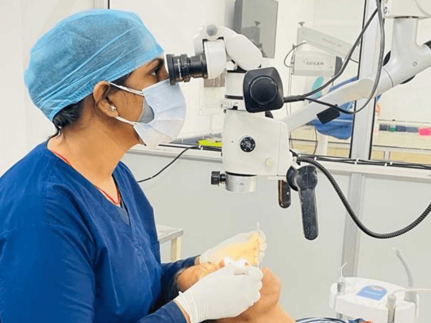 Dr. Shipra Jain working under a dental operating microscope at Mahavirai Dental
